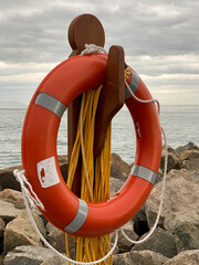 Bouée de sauvetage orange sur le bord d'une jetée. Anneau de sécurité pour des sauvetage en...