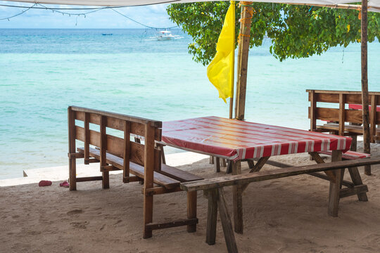 A Wooden Table And Bench With A Linoleum Covered Top Right By The Beachfront. At Libaong Beach, Panglao, Bohol, Philippines.