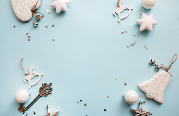 Christmas or New Year's flat lay composition of Christmas or New Year's flat lay composition of various decorative elements, sparkles and Christmas decorations in white and silver colors on a pastel l