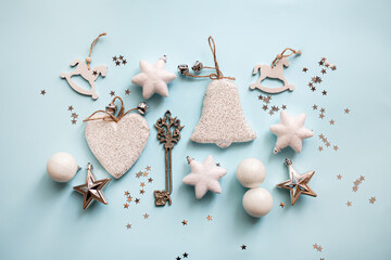 Christmas or New Year's flat lay composition of Christmas or New Year's flat lay composition of various decorative elements, sparkles and Christmas decorations in white and silver colors on a pastel l