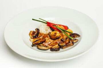 tasty shiitake mushrooms, chicken and vegetables served on a white plate on white background
