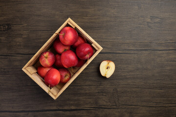 Small red Autumn Strawberry shaped Apple cut slice seed in wooden crate box on rustic wooden background