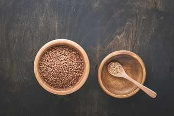 World food crisis concept. Empty and full old plate with buckwheat on a dark gloomy background....