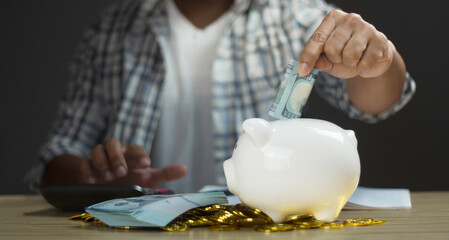 Man putting banknote to piggy bank for account save money. Planning step up, saving money for future plan, retirement fund. Business investment-finance accounting concept.