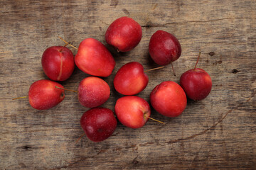 Small red Autumn Strawberry shaped Apple cut slice seed on rustic wooden background