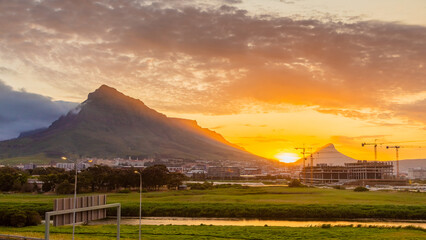 Naklejka premium Construction cranes on building site at sunset in Cape Town