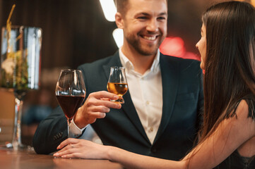 Sitting and drinking. Man and woman is together in the bar