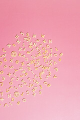 Pasta in the form of letters and numbers on a pink background.Background