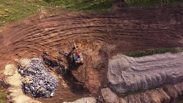 Excavator filling bucket with semi-dry concrete on construction site Excavator filling bucket with semi-dry concrete on construction site Aerial shot