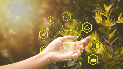 Green Energy CO2 and Environment concept female hands showing icons representing economical use of...