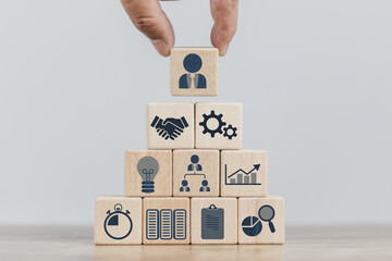 insurance concept, a man's hand is building a cube wood to show the decision about life insurance to plan the future for themselves and their families on money, health and tax breaks.