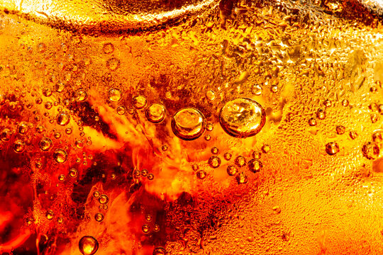 macro cola background,Macro black bubbles on cola's glass wall,Cola background with ice and bubbles