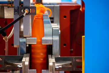 The orange bottle container manufacturing process by blow mold machine.