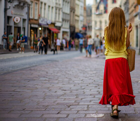 Beautiful blonde girl walks in the street carrying a bag
