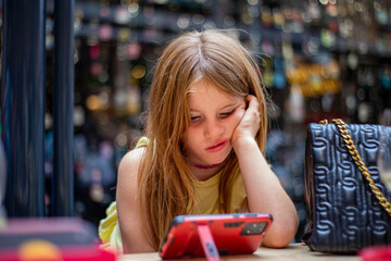 Beautiful blonde girl looks cellphone bored