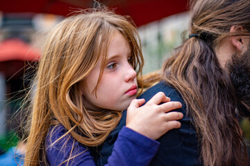 Beautiful tired blonde girl is carried by a man on his back