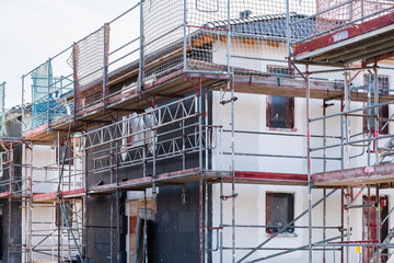 Gerüst vor Neubauten mehrerer gedämmter Einfamilienhäuser