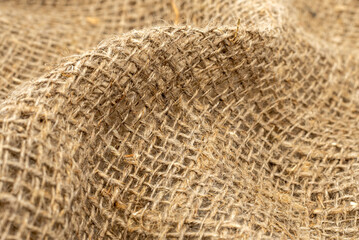 Burlap texture. Burlap fabric background with waves, folds and bruises