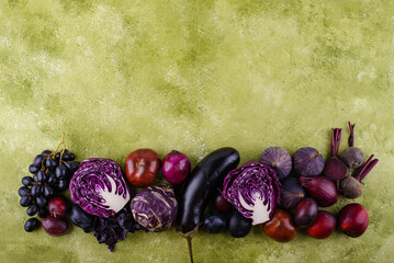 Assortment of purple vegetables on green background
