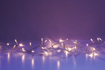 Warm white LED lights on Purple Blue background - copy space above and below string of lights ideal...