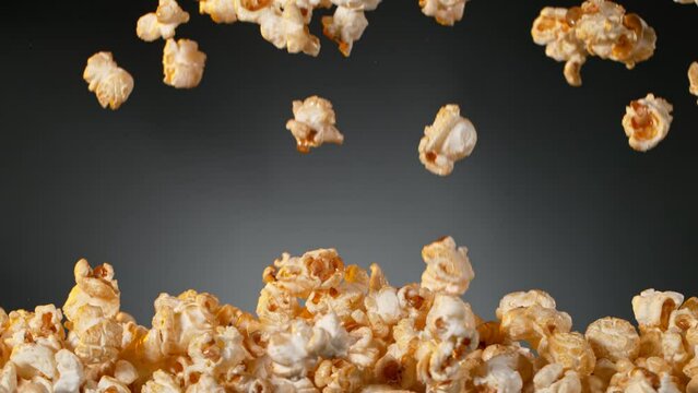 Super Slow Motion of Popcorn Flying on Gradient Dark Grey Background. Filmed on High Speed Cinematic Camera at 1000 fps.