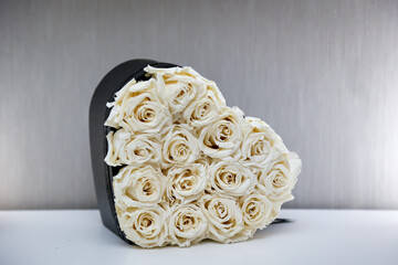 Eine Herzbox gefüllt mit vielen weißen Rosen. Motiv für Valentinstag.