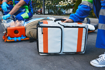 First aid from ambulance workers to injured unconscious patient. Emergency medical technicians
