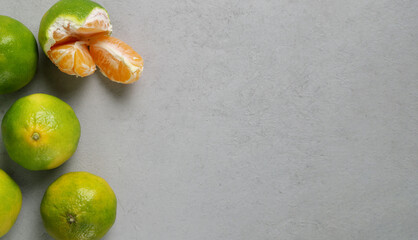 Green fresh tangerines on a gray stone background. Copy space. Top view