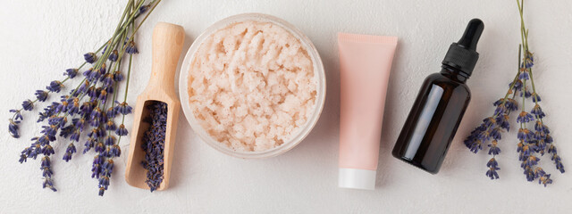 SPA. Lavender flowers, scented candle, body cream, essential oil, scrub and handmade soap. Natural herbal cosmetics with lavender flowers on a white texture background.FLET LAY © Avocado_studio