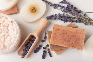 Obraz na płótnie Canvas SPA. Lavender flowers, scrub and handmade soap. Natural herbal cosmetics with lavender flowers on a white texture background.FLET LAY
