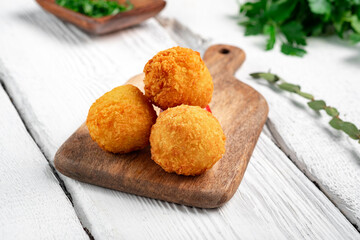 Fried potato croquettes with cheese on a wooden board. Snack with potato balls