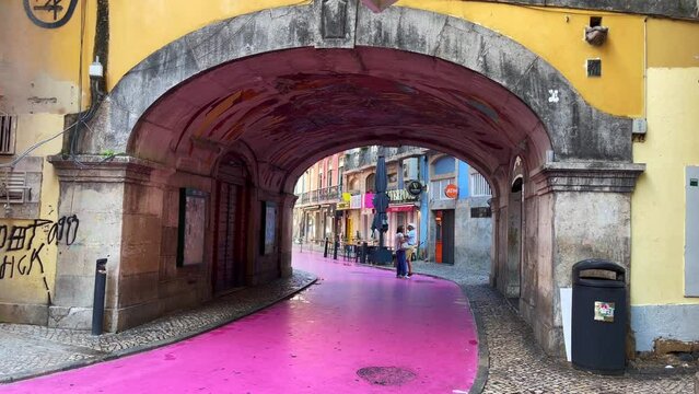 Adult couple hanging out on the pink street in Lisbon