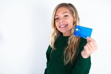 Close up photo of optimistic beautiful caucasian teen girl wearing green knitted sweater over white wall hold card