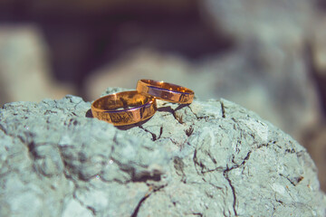 Traditional gold marriage rings on the blue clay background. Wedding concept, honeymoon
