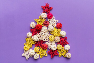 Christmas tree made from colored handmade ball decoration on colored background, view from above. New Year minimal concept with copy space