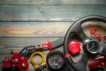 Sport car tuning accessories on the wooden workbench flat lay background with copy space.