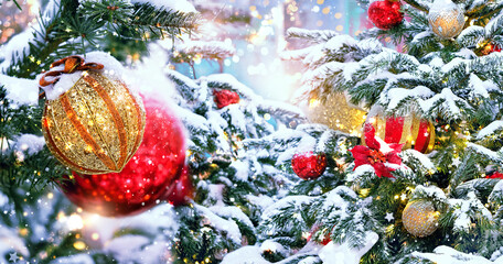 Christmas holiday background. bright balls and decorations on snowy Christmas tree outdoor. festive winter season. banner. 