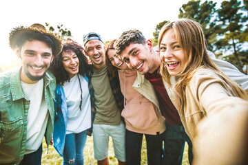 Cheerful young people smiling at camera together outdoors - Happy group of friends taking selfie...