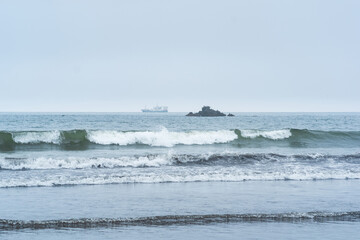 landscape with a sea rock and a sailing ship in the distance