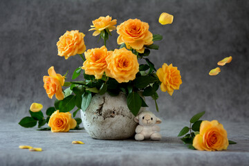 Bouquet of cream roses in a flowerpot, floating petals and toy sheep on grey background - 542755134