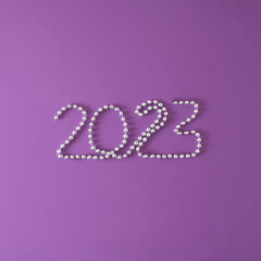 Christmas, New Year 2023 concept of  jewelry isolated on purple background. Minimal holiday design. Flat lay with copy space..