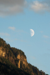 white moon next to swiss mountain
