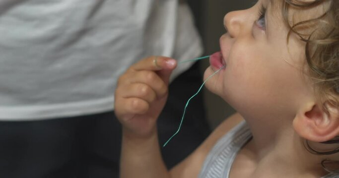 Child dental floss. Mother helping son to floss teeths. Bedtime night routine