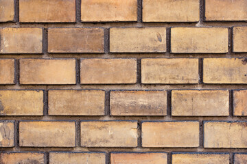 Close up to a wall made of yellow bricks and cement