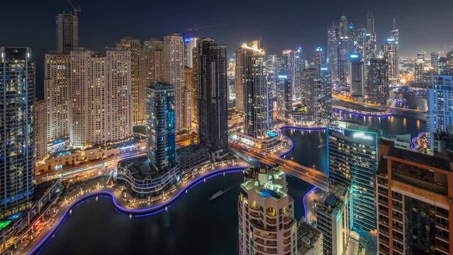 View of various skyscrapers in tallest recidential block in Dubai Marina and JBR district aerial day to night transition timelapse with artificial canal. Many towers and yachts after sunset