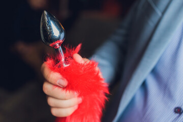glass sex toy in men's hands in black background.