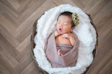 かごの中であくびする生まれたての赤ちゃん（ニューボーンフォト）
