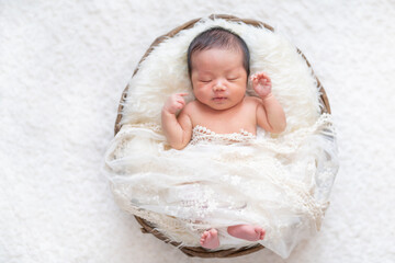 かごの中ですやすや眠る生まれたての赤ちゃん（ニューボーンフォト）