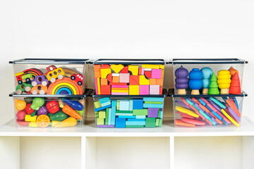 Transparent plastic containers with various children's toys on shelves. Organizing and Storage...
