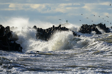 Big waves crash against the harbor breakwater concrete tetrapods during stormy weather